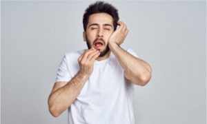 a man having a headache after tooth extraction